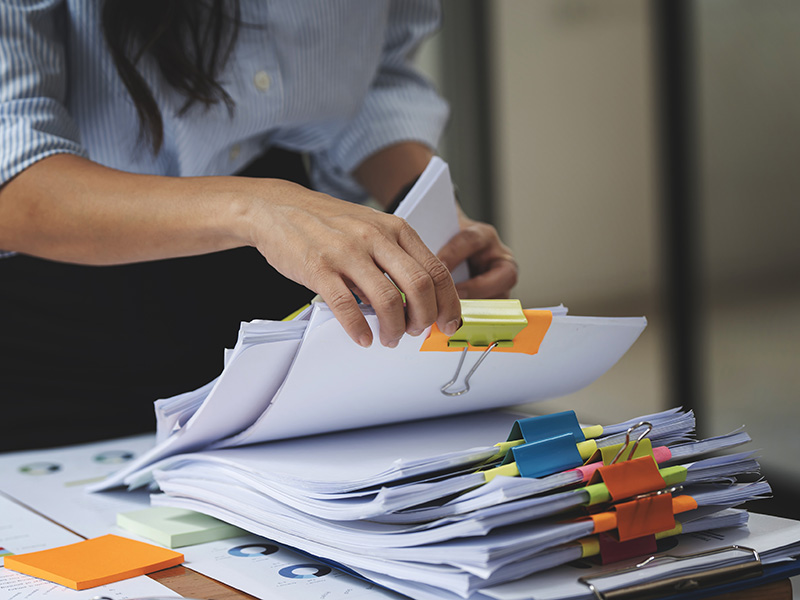 Mani che organizzano curricula e documenti durante lo screening dei candidati